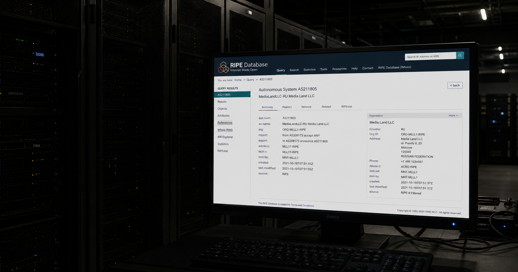 A dark server room with an illuminated registry terminal displaying AS211805 under the name 'MediaLandLLC-RU Media Land LLC', surrounded by unlit network equipment.