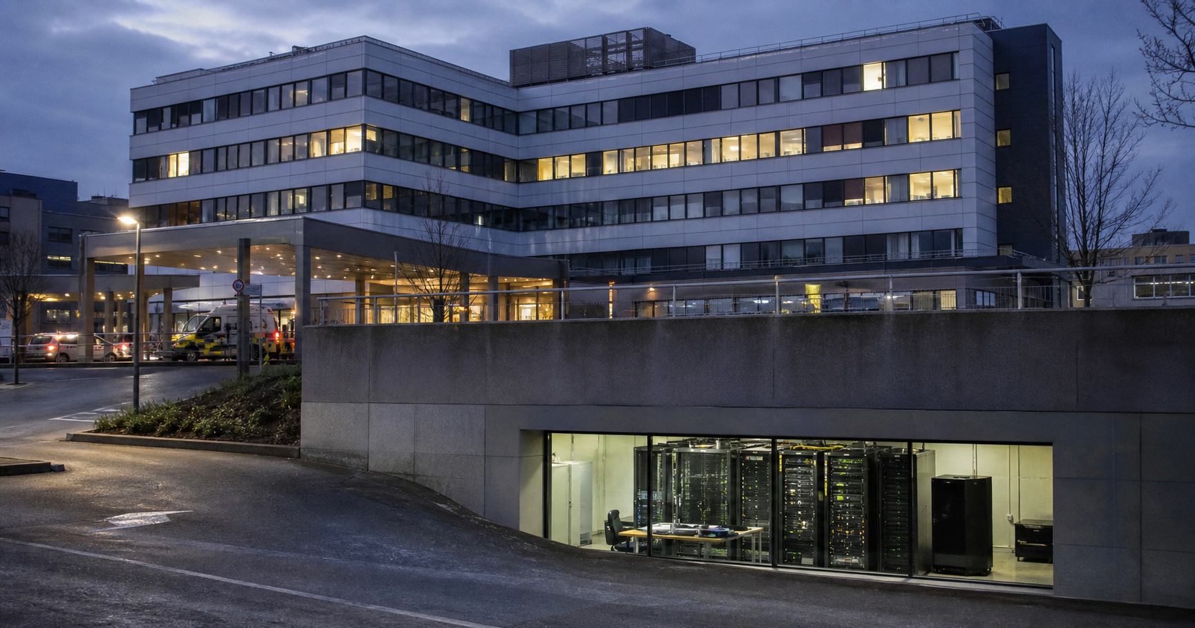 A Belgian hospital at dusk with a basement server room visible through a window, showing a dormant network switch rack labeled AS211602, a dangling patch cable, and a faint LED glow.