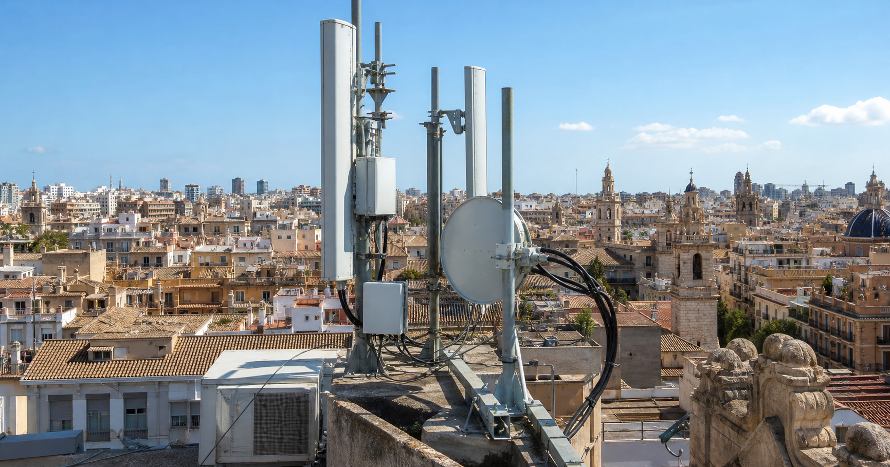 Photograph of wireless telecommunication antennas and network equipment on a rooftop in Valencia, Spain.