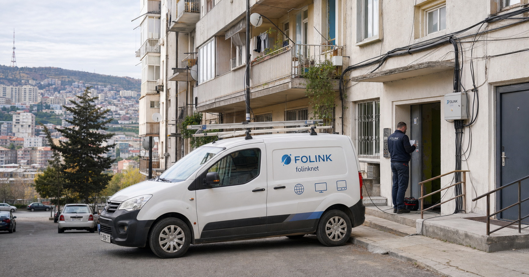 A technician connects fiber outside a Tbilisi building while a family indoors watches football via Folink TV, illustrating local dependency on the ISP's bundled internet and television service.