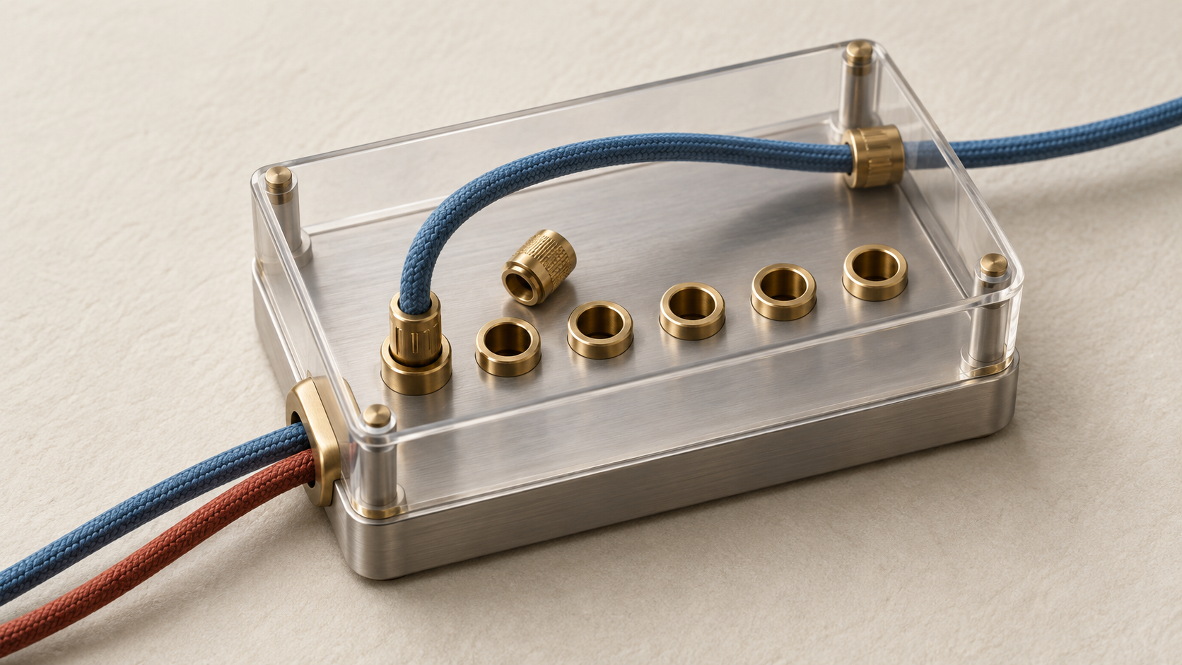 Blue and rust-red cords enter a bounded metal relay model with brass sockets and a detached connector.