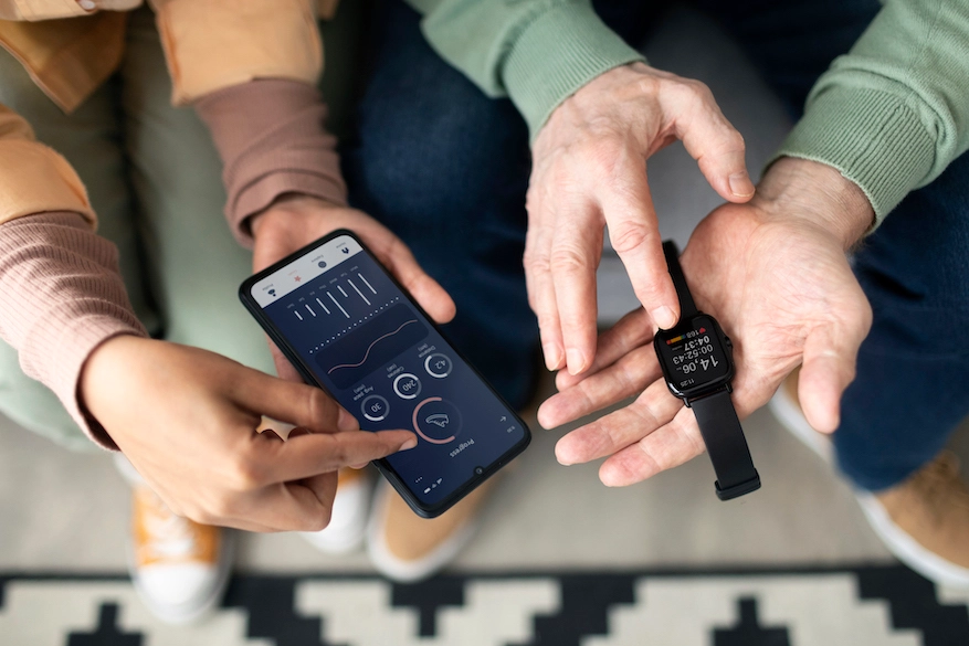 -arabic-woman-teaching-senior-man-use-smartwatch-with-smartphone-